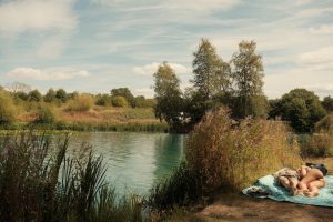 People relaxing beside a lake, photographed with a Fujifilm X-E5 using a custom film recipe